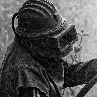 Man in protective gear holding abrasive blasting hose