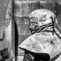 Man in protective gear using abrasives to blast wall clean black and white image